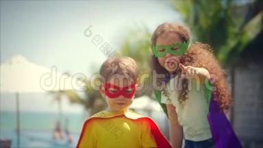 穿着超级英雄服装、斗篷和面具的孩子们<strong>扮演</strong>着英雄，在公园的夏日小路上玩得很开心